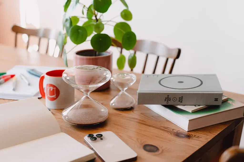 Photo of a table with books and an hourglass