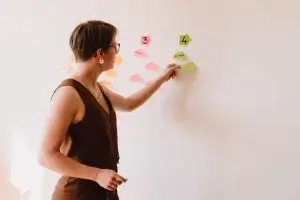 Photo of Juliette placing sticky notes on the wall during a work session