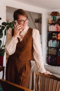 Photo de Juliette au téléphone avec une de ses cliente. elle se tient debout et souris